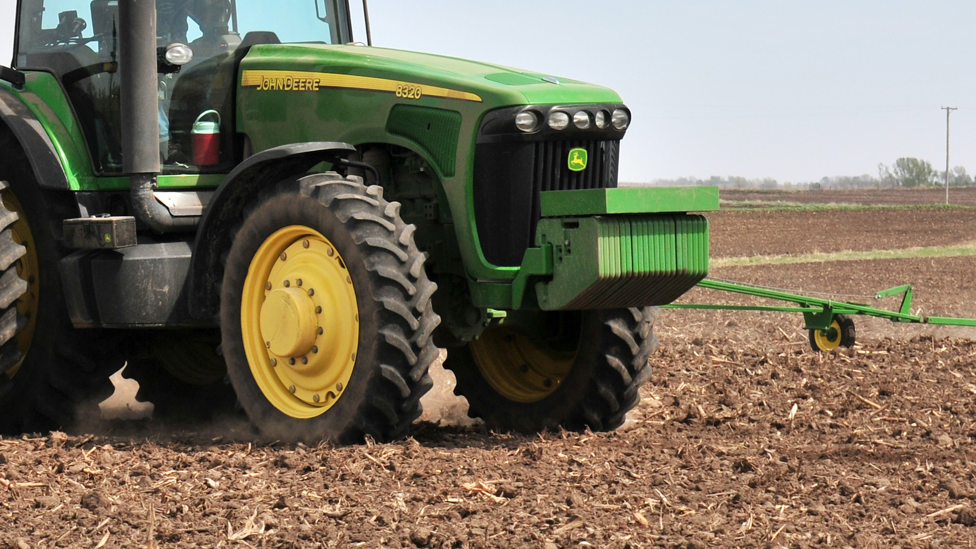 John Deere tractor running through field showcasing the perfect tractor ballast